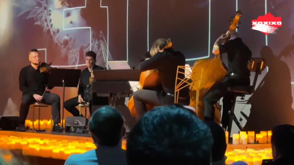 Cvartet de coarde live la concertul Candlelight România: doi violoniști, violist și pianist pe scenă, înconjurați de lumânări aprinse și public captivat