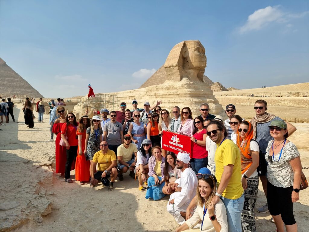 Grupul Hai să socializăm zâmbitor și plin de energie în fața Sfinxului și a piramidelor din Giza, Egipt – dovada vie că pleci cu un autocar din București și te întorci cu prieteni pe viață din cele mai exotice colțuri ale lumii